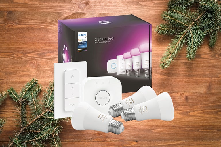 Set de pornire Philips Hue cu becuri, bridge și variator pe o masă de lemn