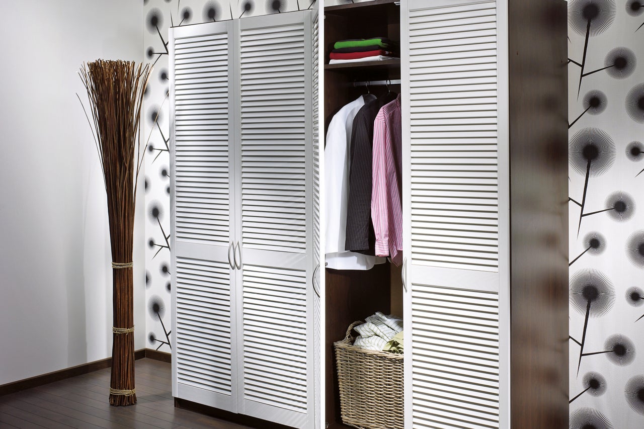 Scenă de dormitor cu dulap deschis cu uși tip jaluzea și decorațiuni