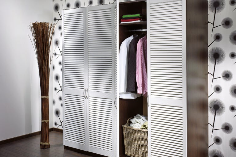 Scenă de dormitor cu dulap deschis cu uși tip jaluzea și decorațiuni