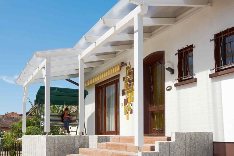 Acoperiș de terasă din lemn la o casă cu mobilier de grădină