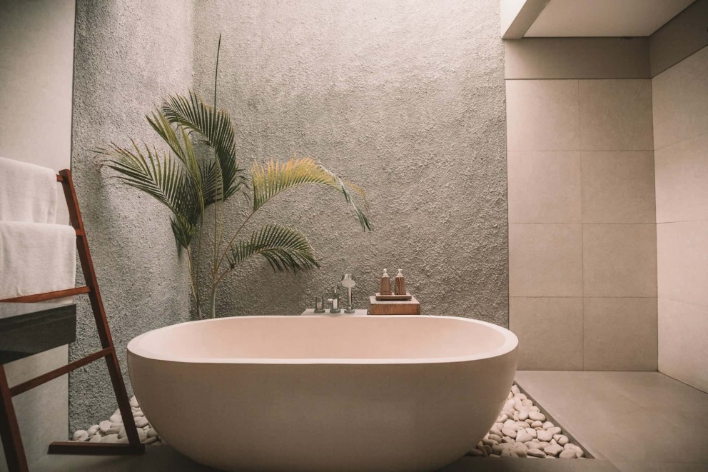 Baie în stil scandinav – cadă freestanding, plantă, suport prosoape, pietre, finisaje în culori neutre Baie în stil scandinav – cadă freestanding, plantă, suport prosoape, pietre, finisaje în culori neutre