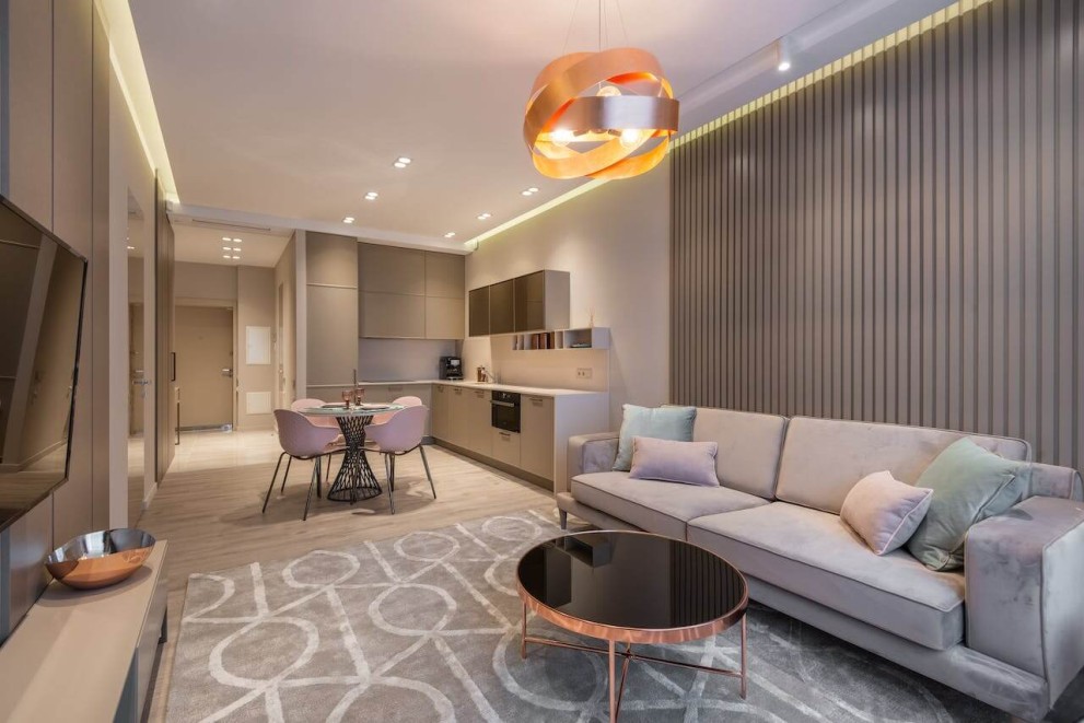 Cameră de zi modernă cu canapea, masă și iluminat decorativ
