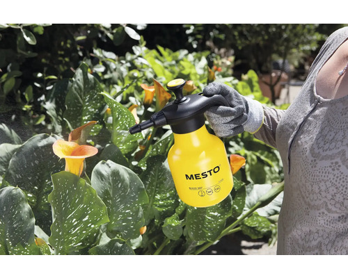 O persoană folosește un pulverizator cu presiune Mesto galben pentru îngrijirea plantelor.