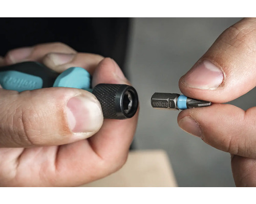 Persoană care ține un bit de șurubelniță și un suport de biți Wolfcraft.