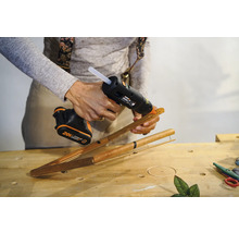 O persoană lipește bețe de bambus cu un pistol de lipit fără fir.