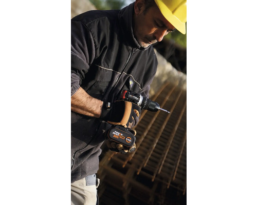 Bărbat cu cască de construcție galbenă folosind o șurubelniță cu acumulator