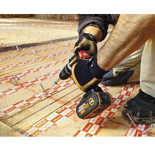 Artizan care fixează o scândură de lemn cu o mașină de găurit cu acumulator