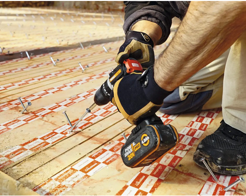 Artizan care fixează o scândură de lemn cu o mașină de găurit cu acumulator