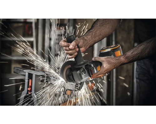 O persoană folosește un polizor unghiular cu acumulator pentru a tăia metal, cu scântei zburând.