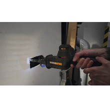 O persoană taie o gaură într-un perete cu un fierăstrău sabie. Unealtă de la Worx Nitro.