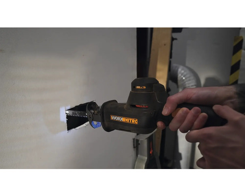 O persoană taie o gaură într-un perete cu un fierăstrău sabie. Unealtă de la Worx Nitro.