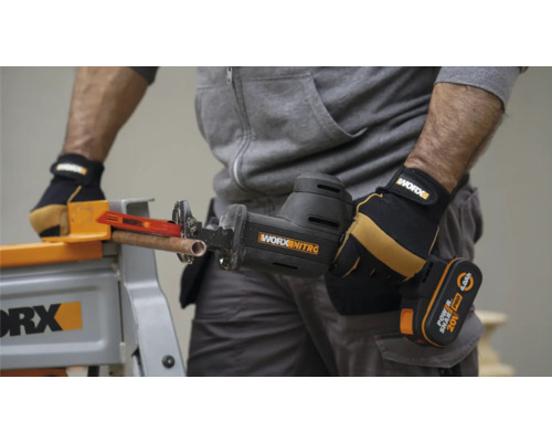 Fierăstrău sabie cu acumulator tăind țeavă de cupru pe bancul de lucru