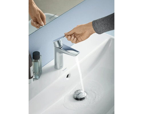 Fotografie cu o chiuvetă cu robinetul pornit și o mână care acționează robinetul