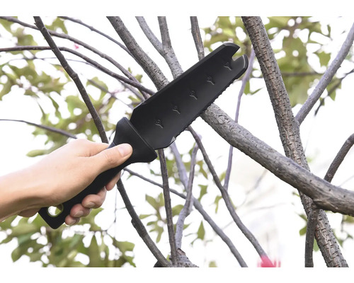 O mână ține un topor multifuncțional de grădină folosit pe o ramură