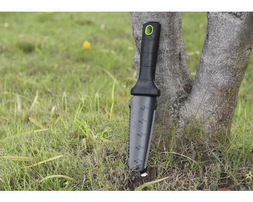 Unealtă de grădinărit cu mâner și scară de măsurare sprijinită de un copac