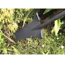 Cazma de grădină cu dinți de ferăstrău în grădină.