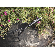 Cultivator de grădină pe o piatră printre plante