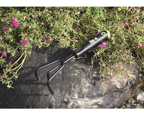 Cultivator de grădină pe o piatră printre plante