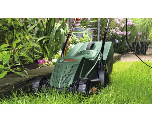 Mașină de tuns iarba folosită în grădină printre plante