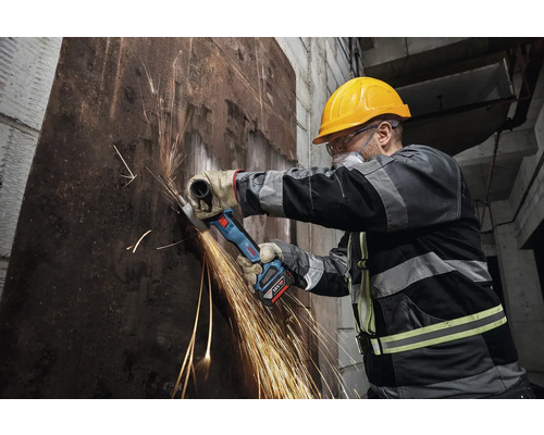 Muncitor tăind metal cu un polizor unghiular cu acumulator