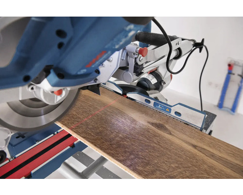 Fierăstrău circular tăind o scândură de lemn cu ghidare laser.