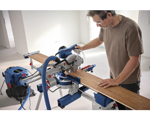 Bărbat care operează un ferăstrău circular Bosch cu o piesă de lucru și un aspirator