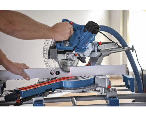 Un ferăstrău circular de tăiat în unghi utilizat la tăierea unei piese de lucru.