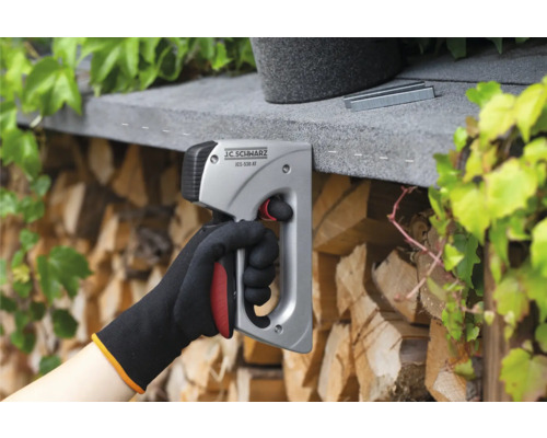 O mână folosește un capsator J.C. SCHWARZ pentru a fixa capse.