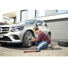 Un bărbat schimbă o anvelopă la o mașină cu o cheie de impact.