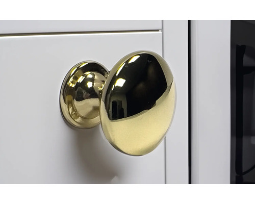 Buton auriu pentru mobilă pe suprafață albă