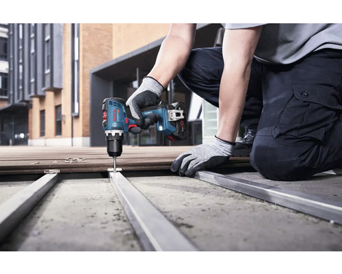 O persoană folosește o șurubelniță electrică pentru a înșuruba un element metalic.