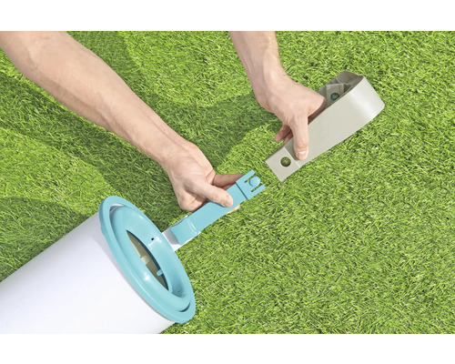 Persoană care asamblează o scară de piscină pe un gazon.