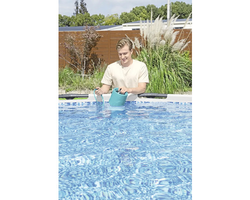 Bărbat turnând lichid de curățare într-o piscină