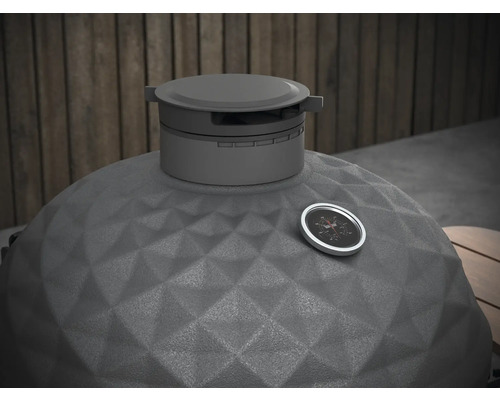 Prim-plan al unui grătar kamado cu indicator de temperatură și suprafață ceramică texturată