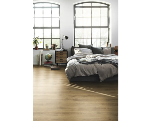 Dormitor luminos cu podea din lemn, pat, noptieră și ferestre mari