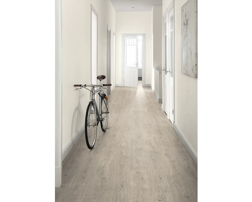 Hol cu parchet laminat deschis la culoare, pereți albi și o bicicletă