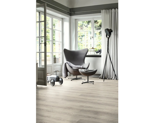 Living luminos cu fotoliu, lampadar, podea din lemn și fereastră mare