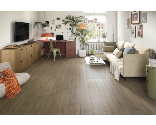 Living luminos cu podea din lemn, canapea, birou și decorațiuni pentru o ambianță confortabilă.