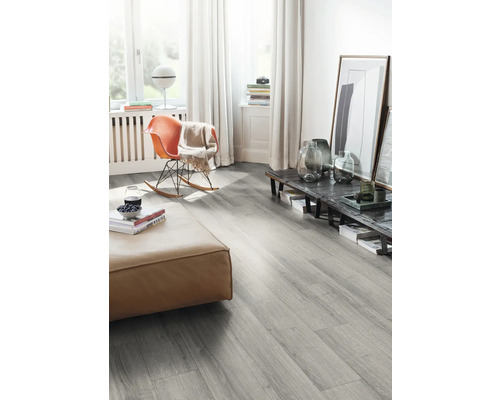 Living cu podea laminată gri, taburet și balansoar.