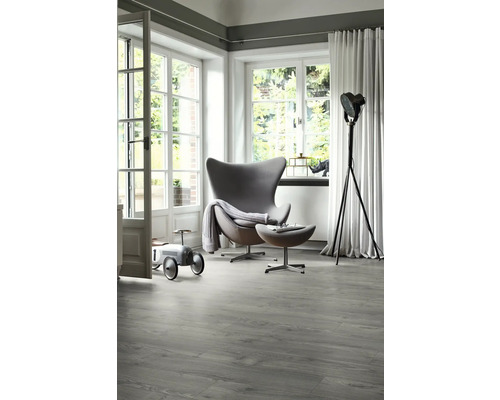 Cameră luminoasă cu fotoliu modern, lampă de podea și podea de vinil gri cu aspect de lemn