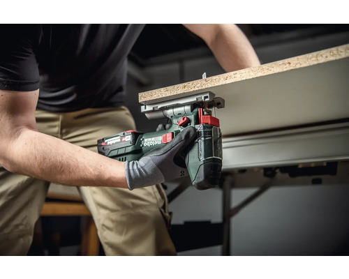 Artizan care folosește o foarfecă de tablă fără fir Metabo pentru a tăia o piesă de lucru