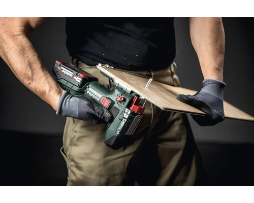 Artizan care taie o scândură cu un ferăstrău electric fără fir Metabo