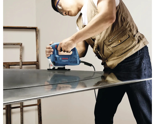 O persoană folosește un fierăstrău vertical marca Bosch Professional pentru a tăia o bucată de metal.