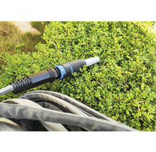 Furtun de grădină cu conector pe o plantă verde
