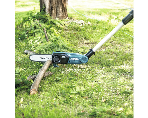 Drujba cu acumulator Makita tăind o ramură în grădină.