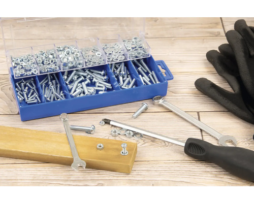 Cutie de sortiment cu șuruburi și piulițe, chei, șurubelniță și mănuși pe o masă de lemn