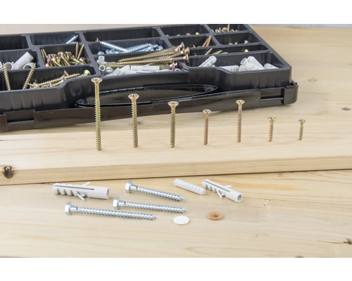 Cutie de sortiment cu diverse șuruburi și dibluri pe fundal de lemn