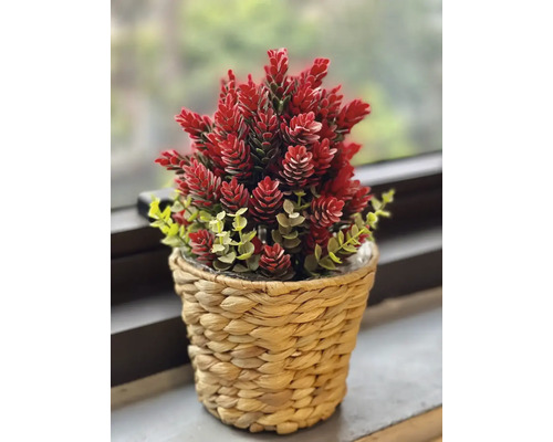 Plantă artificială cu flori roșii într-un ghiveci împletit