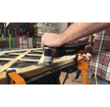 Un bărbat taie lemn cu un multi-instrument oscilant de la Worx