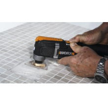 Imagine detaliată cu o persoană care lucrează la gresie cu un instrument multifuncțional, marca Worx